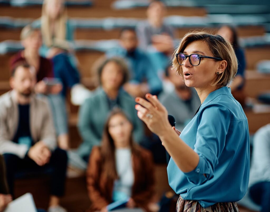 woman-speaking-at-conference-min