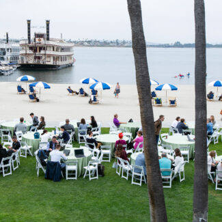 conference attendees sitting at tables on the beach