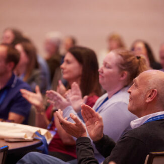 session attendees at a table clapping